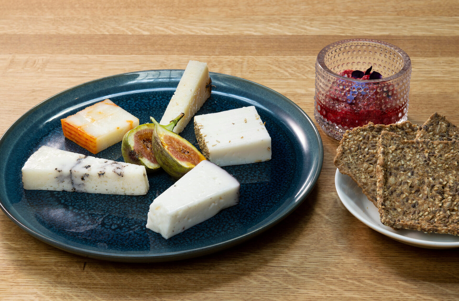 Juustolajitelma, vadelmalla maustettua viikunahilloketta ja spelttinäkkileipää